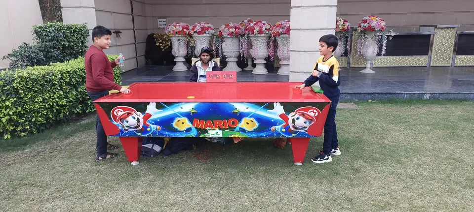 Kids enjoying an air hockey table during a Jaipur celebration