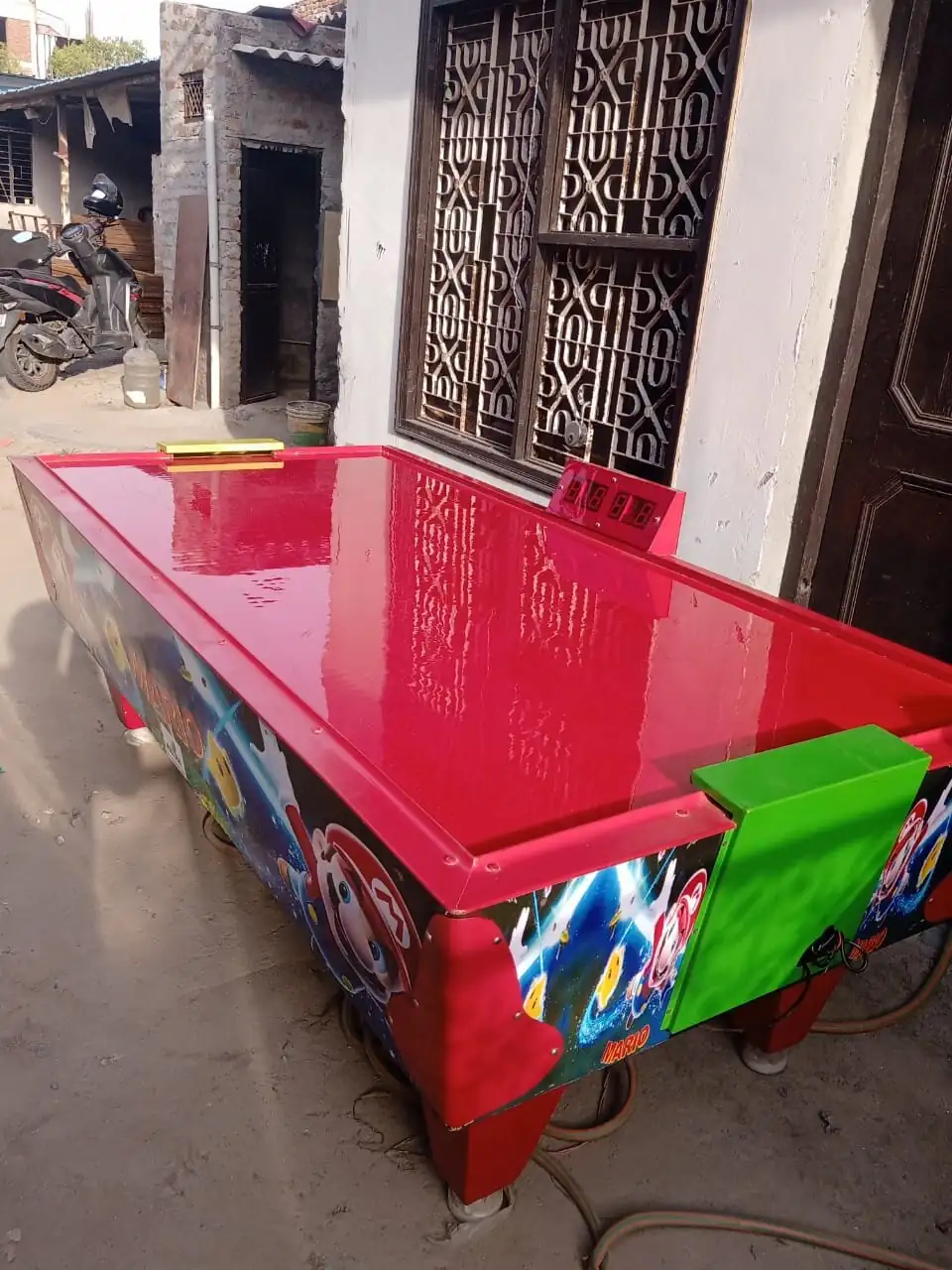 Side view of a red air hockey table ready for event rental in Jaipur