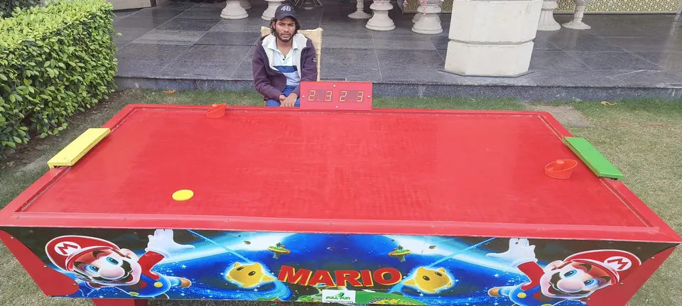 Red air hockey table with digital scoreboard arranged for a Jaipur party