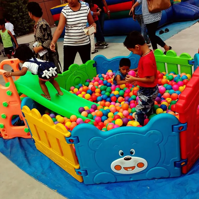 Children playing in a colorful ball pit setup at a Jaipur celebration