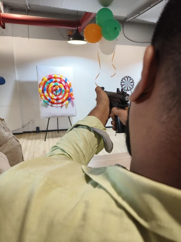 Guest aiming at a balloon shooting target during an event in Kanpur