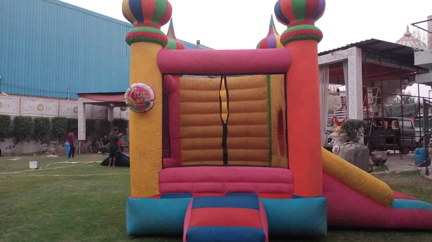 Colourful castle bouncy with side slide for birthday parties