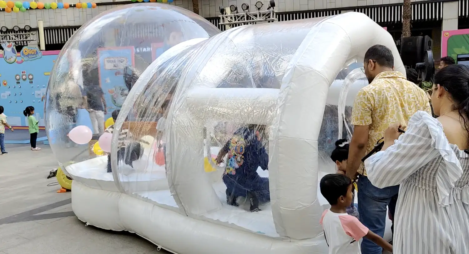 Transparent inflatable bubble house set up at a family event