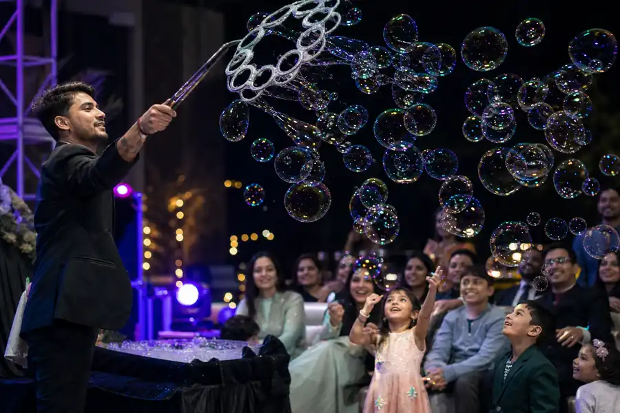 Professional bubble artist creating many iridescent bubbles for event guests