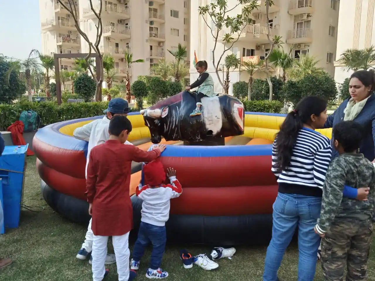 Child enjoying a supervised mechanical bull ride at a family event