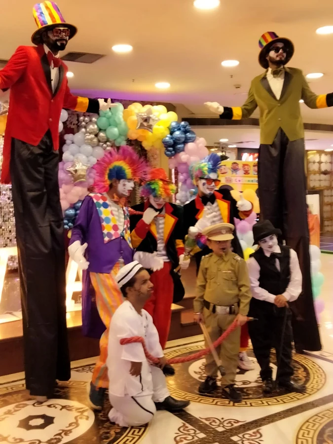 Charlie Chaplin character artists with stilt walkers at a live event